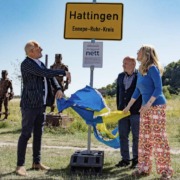 Das Ortschild von Hattingen, fotografiert vor einem Panorama der Stadt